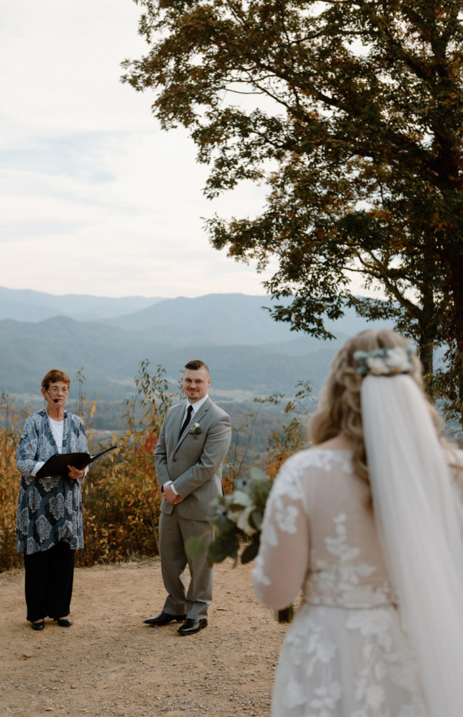 Groom's first look with bride at stunning mountain view overlook elopement location.