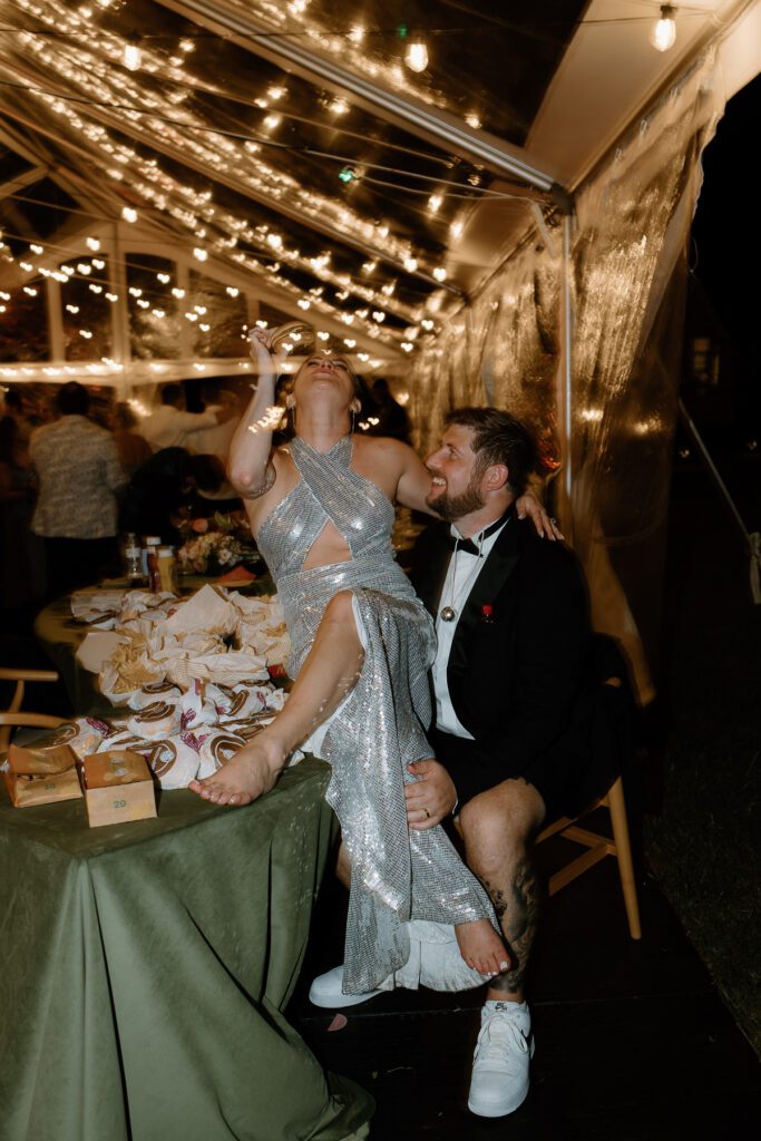 Bride and groom enjoying their reception party with a late night catered snack from McDonald's at summer backyard wedding.