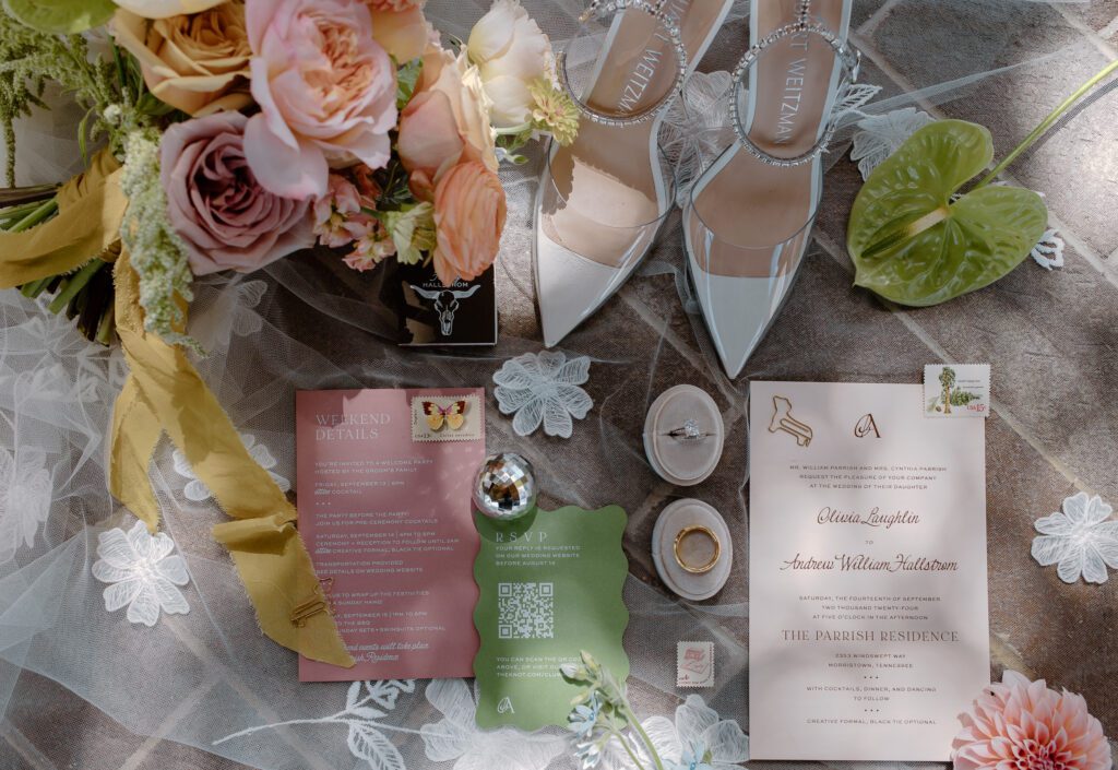 Detail shot of invitation suit flat lay and bride's details with colorful summer wedding bouquet. 