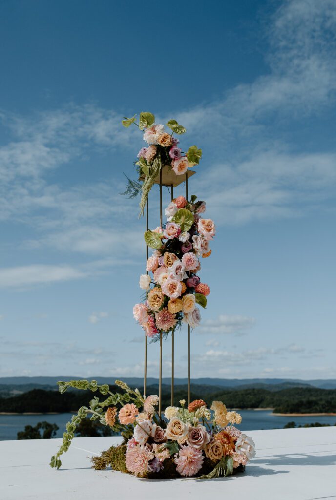 Floral arrangements for ceremony at colorful backyard wedding.