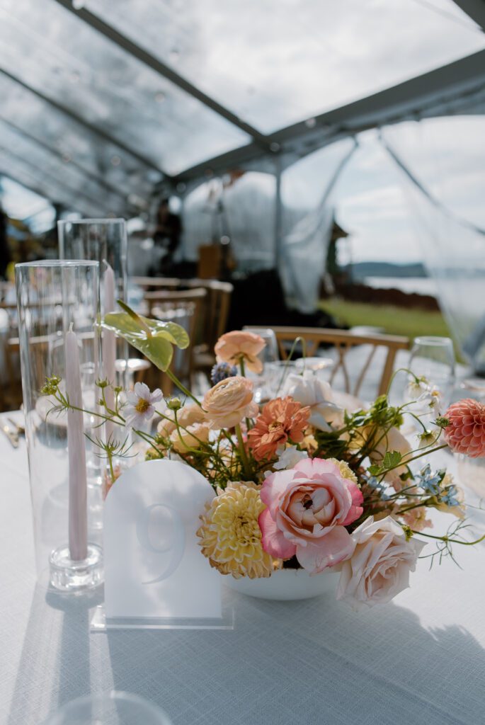 Wedding reception centerpieces with colorful summer floral arrangements for a modern backyard wedding.