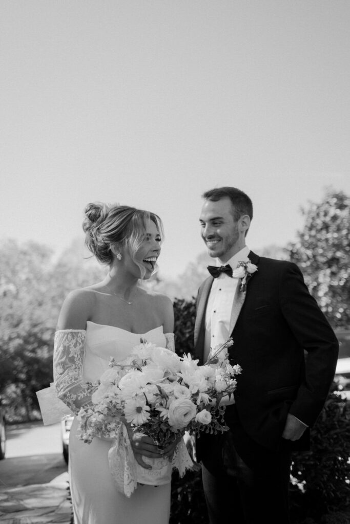 Bride smiles with joy as she is handed her wedding bouquet for the first time. It's candid moments like this that make documentary wedding photography worth while. Taken at Whitestone Inn an east Tennessee wedding venue.