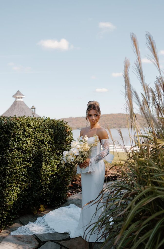 Bride in lace strapless wedding dress poses for her bridal portraits outside Whitestone Inn, an east Tennessee wedding venue.