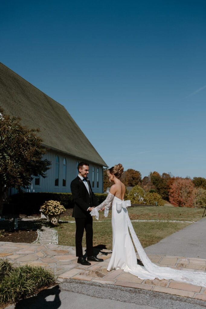Classic bride and groom share their first look in front of the chapel. One of Whitestone Inn's ceremony locations. This is a great waterfront venue for couples looking at east Tennessee wedding venues.