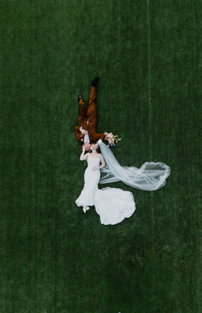 Unique overhead drone photo of bride and groom at their summer garden wedding.