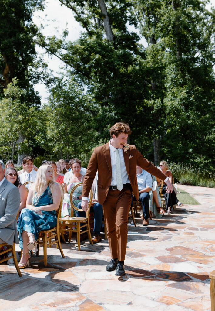 Groom walking down the aisle at The Garden ceremony space at Nichols Heir Summer Garden Wedding in Sevierville, TN
