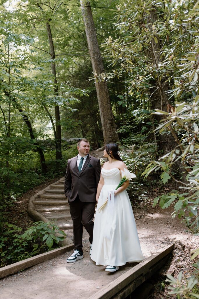 Couple walks across bridge for elopement photos in the Smoky Mountain National Park.