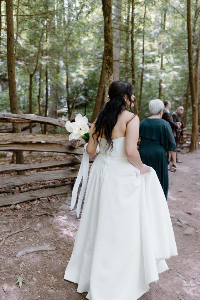 Bride walks up to the waterfall where her wedding ceremony will be held.