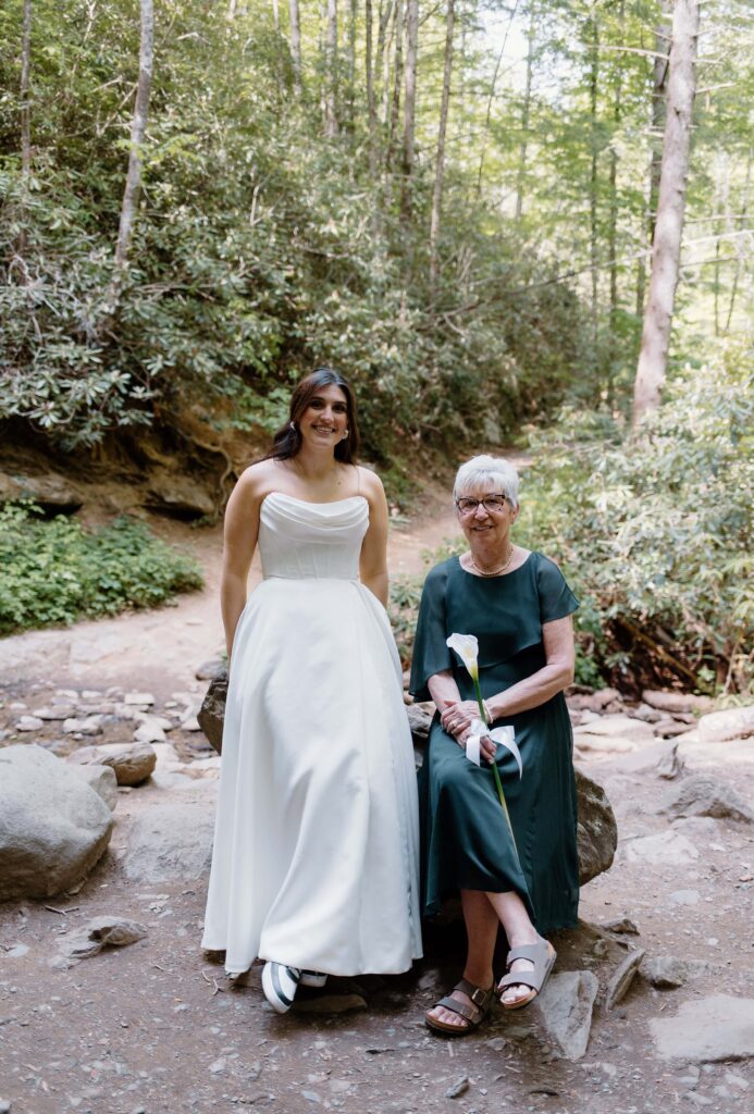 Mother and daughter sit on a rock together as they soak in the moment just before the wedding ceremony begins. Captured by Tennessee elopement photographer.