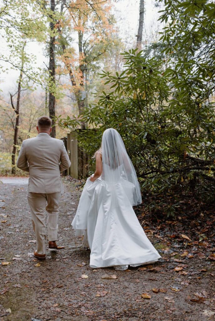 Couple walks to their Great Smoky Mountain elopement ceremony location at Cataract Falls.