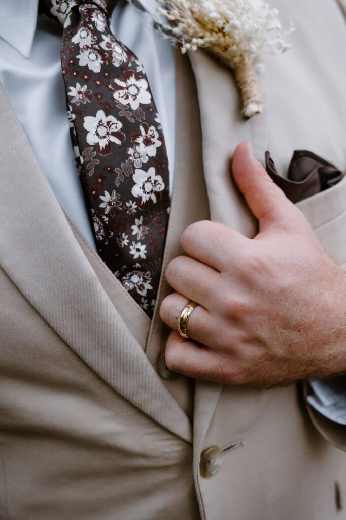 Groom wears a brown floral tie ad beige suite for his fall Great Smoky Mountain elopement. 