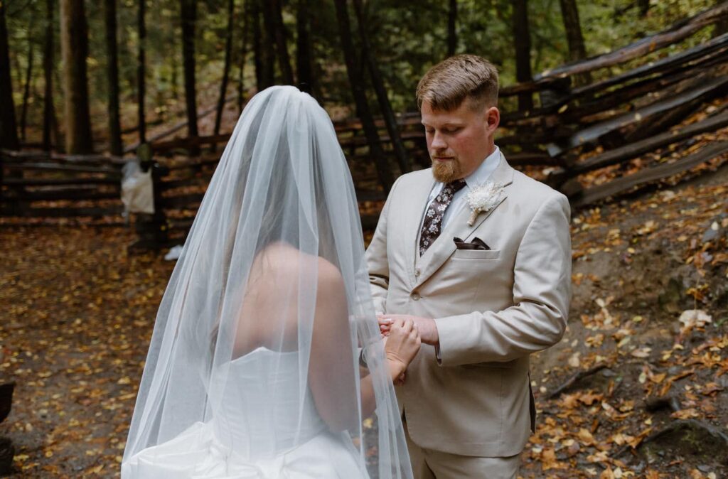 During their Great Smoky Mountain elopement, the bride and groom exchange rings in front of Cataract Falls.