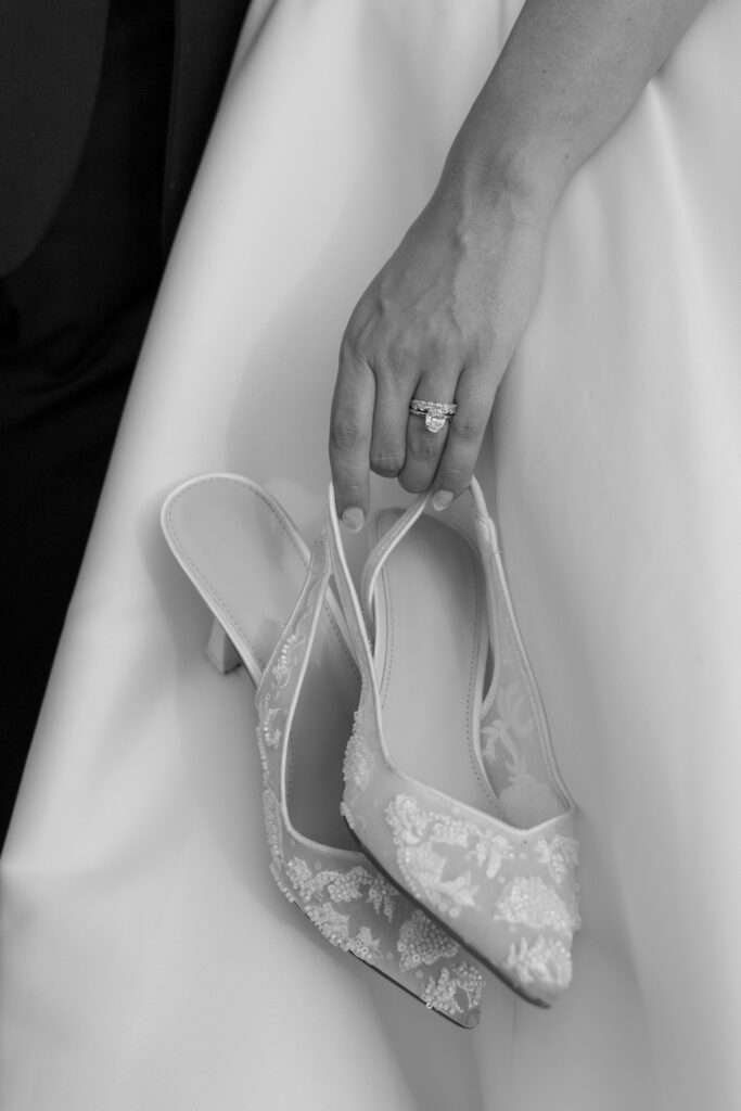 Black and white photo of the bride's ring and her wedding shoes at the Loyston wedding venue in Tennessee.