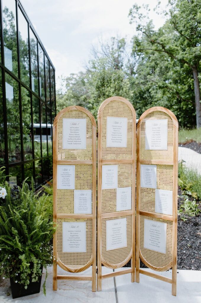 Guest list displayed on rattan trifold stand.