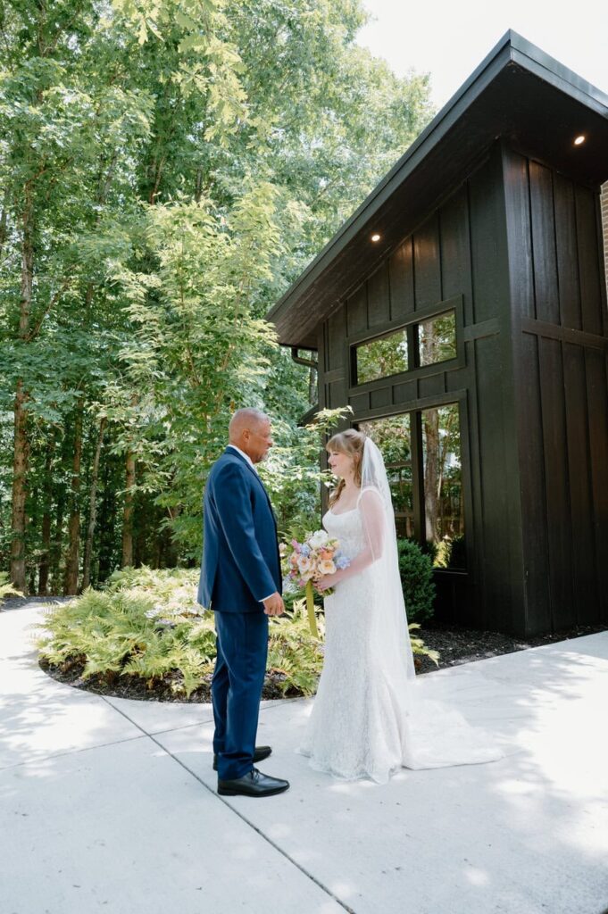 Bride shares a first look with her father in front of the bridal suite on a summer day in Tennessee.