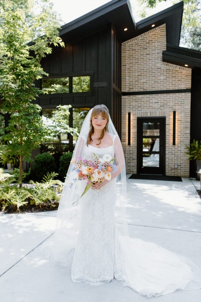 Bride stands in front of the Glass House bridal suite at Nichols Heir wedding venue.