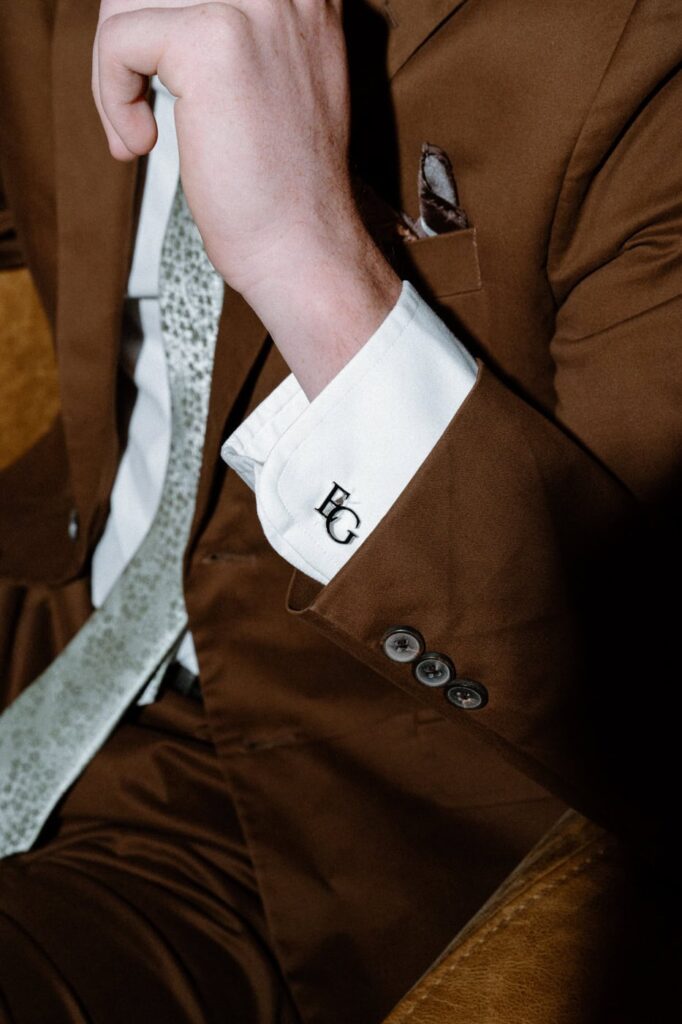 Brown suit with monogrammed cufflinks for summer wedding day.