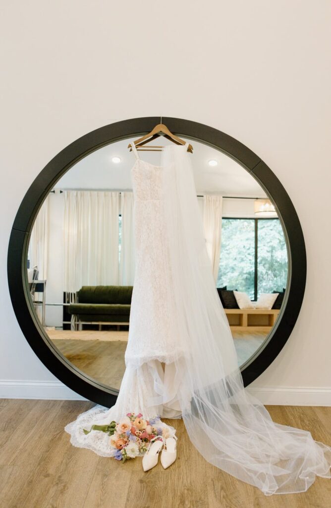 Lace wedding dress hanging on mirror at Glass House bridal suite in Tennessee.