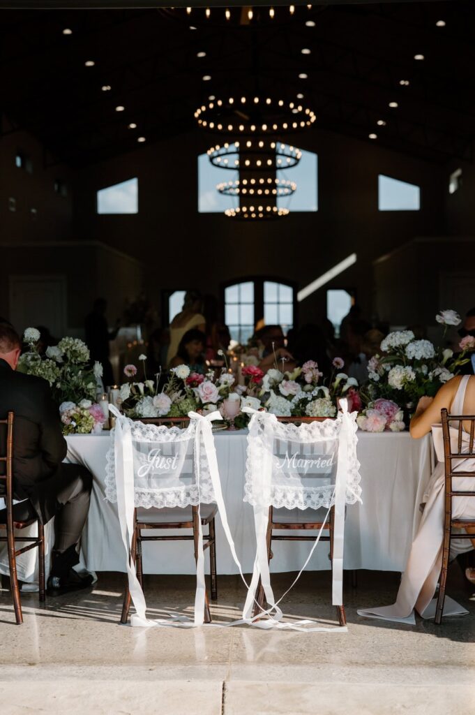 Vintage lace 'Mr.' and 'Mrs.' signs on the back of wedding reception chairs.