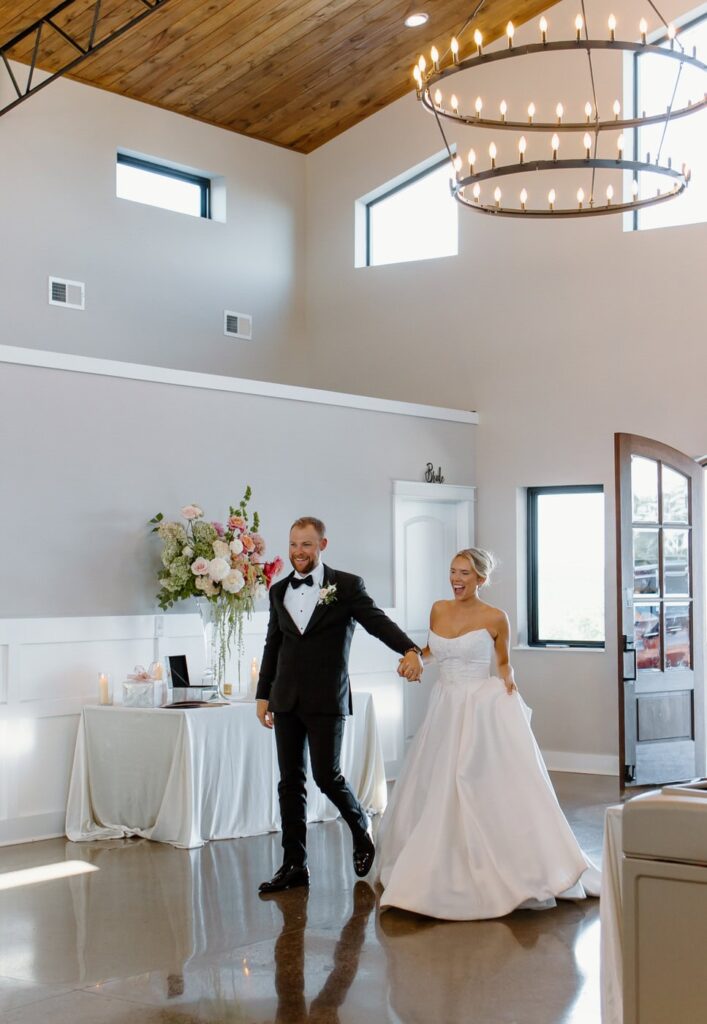 Bride and groom enter their black tie wedding reception at The Loyston Wedding venue.