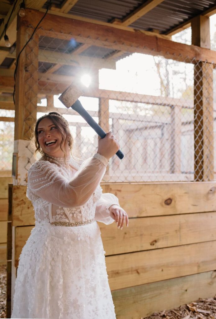 Bride participating in a game of axe throwing during her fall wedding at Ancient Lore Village, Knoxville wedding venue.