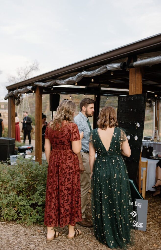 Wedding guest using decorated keys to find their seat at fall wedding at Ancient Lore Village, Knoxville wedding venue.