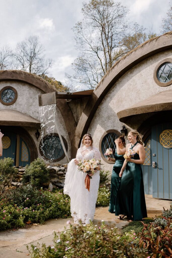 Bride and her bridesmaids walking in front of the village styled lodging at Ancient Lore Village, a Knoxville wedding venue.