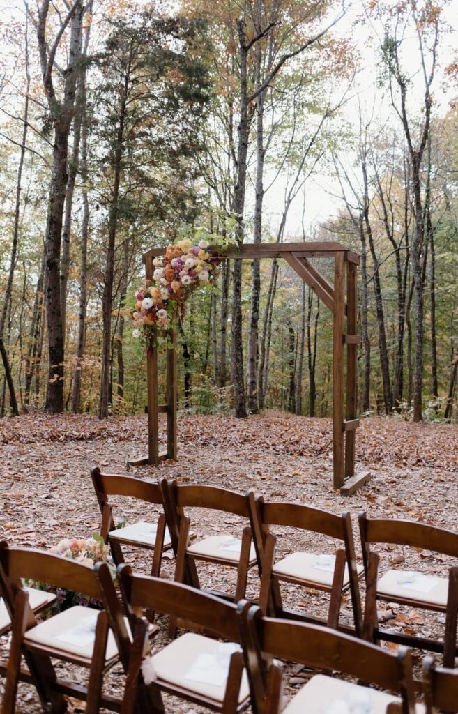 Fall wedding ceremony with gorgeous fall foliage and a soft color palette at Ancient Lore Village, Knoxville wedding venue.